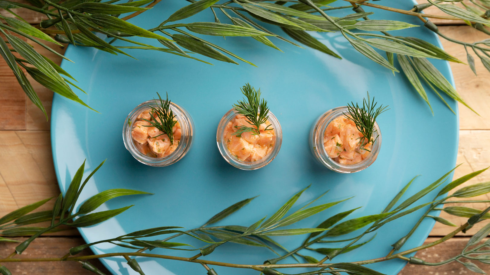 Three individual preparations presented in glasses on a blue tray